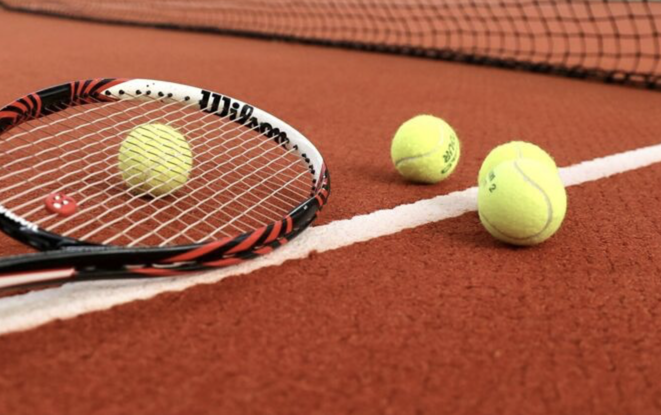 Tennisschläger und Bälle auf einem Tennisplatz - Symbolbild 